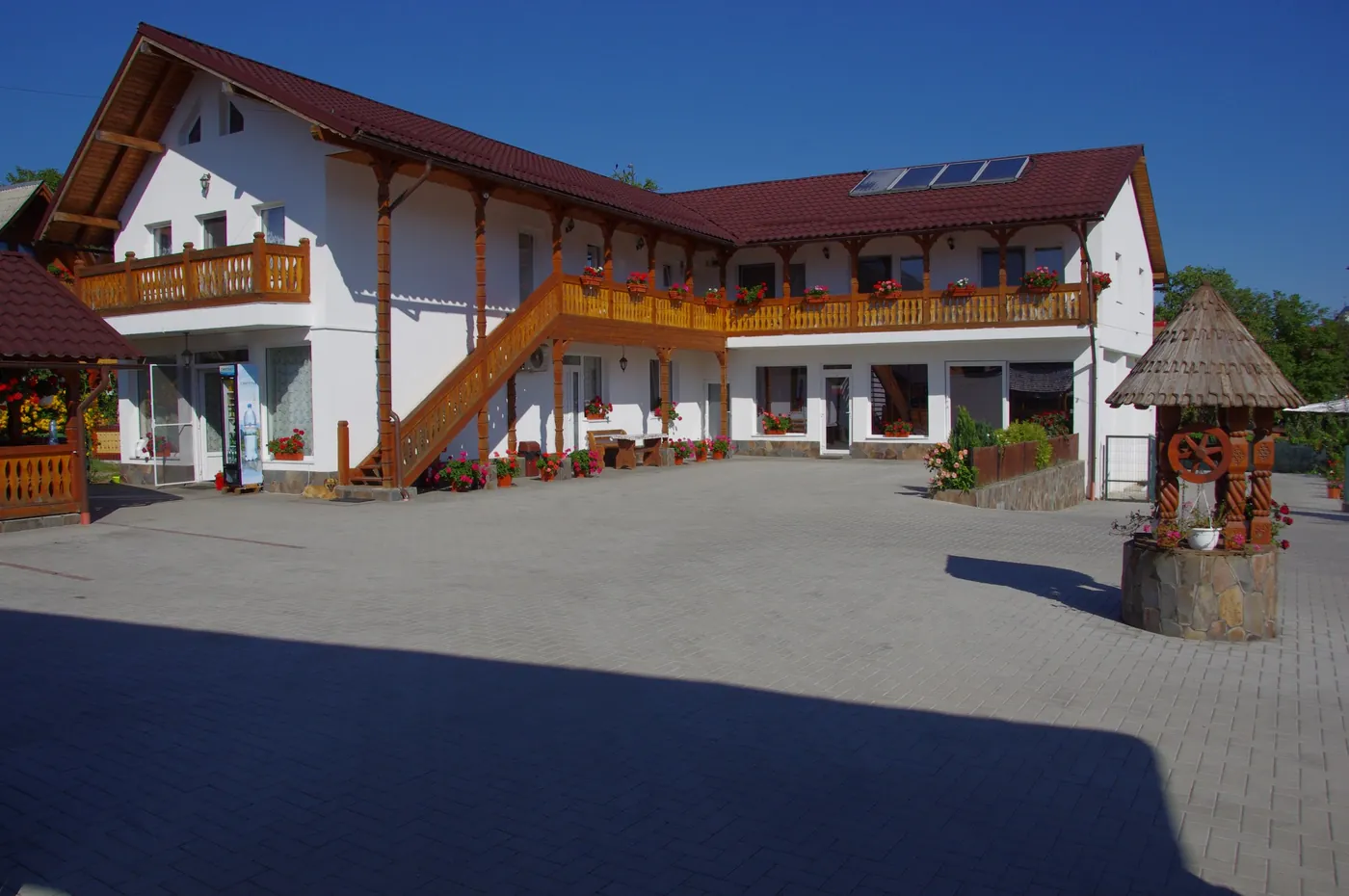 Clădirea principală a pensiunii, cu pridvor și foișor de lemn
