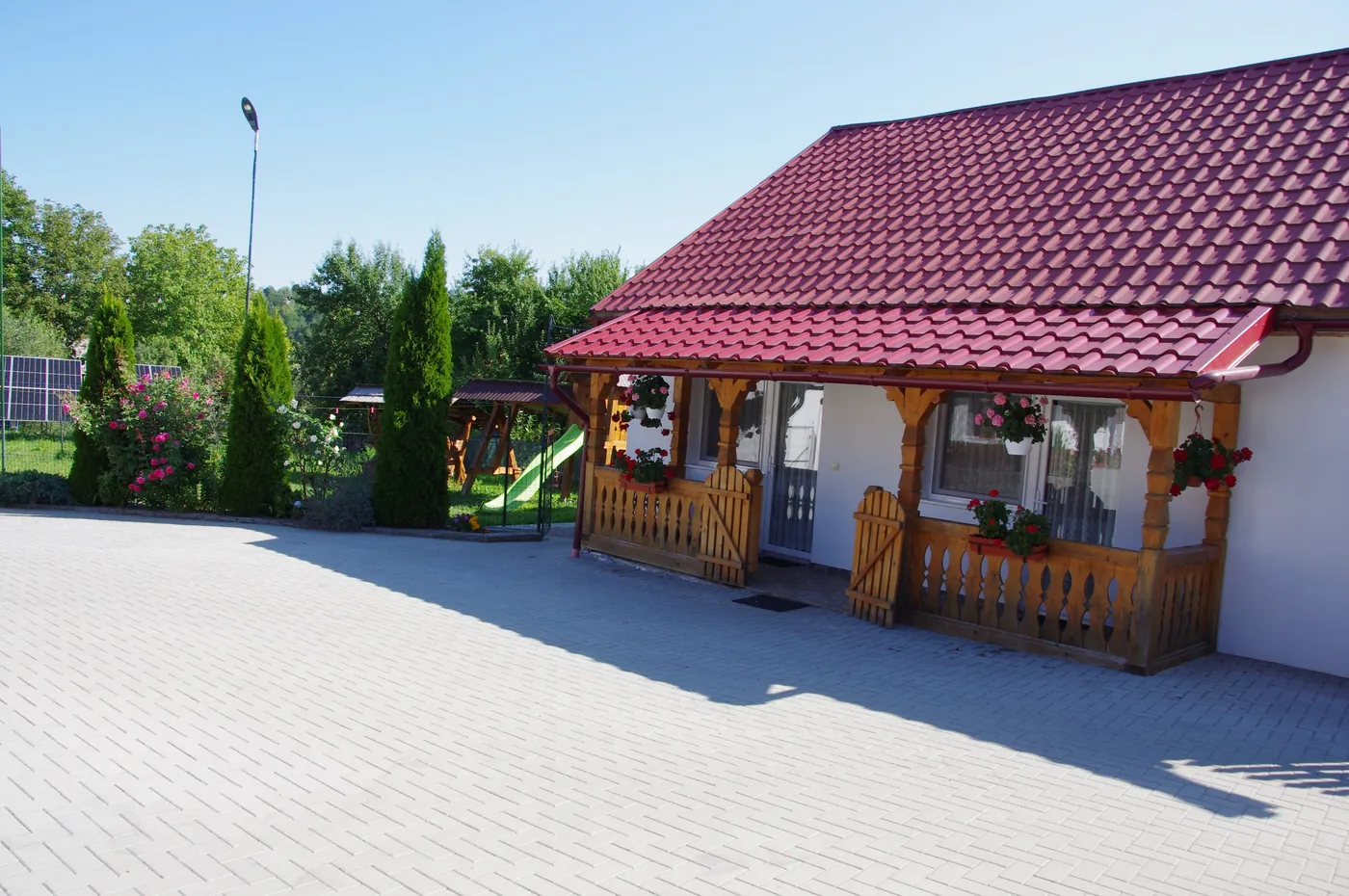 Clădirea cu pridvor de lemn din curtea pensiunii