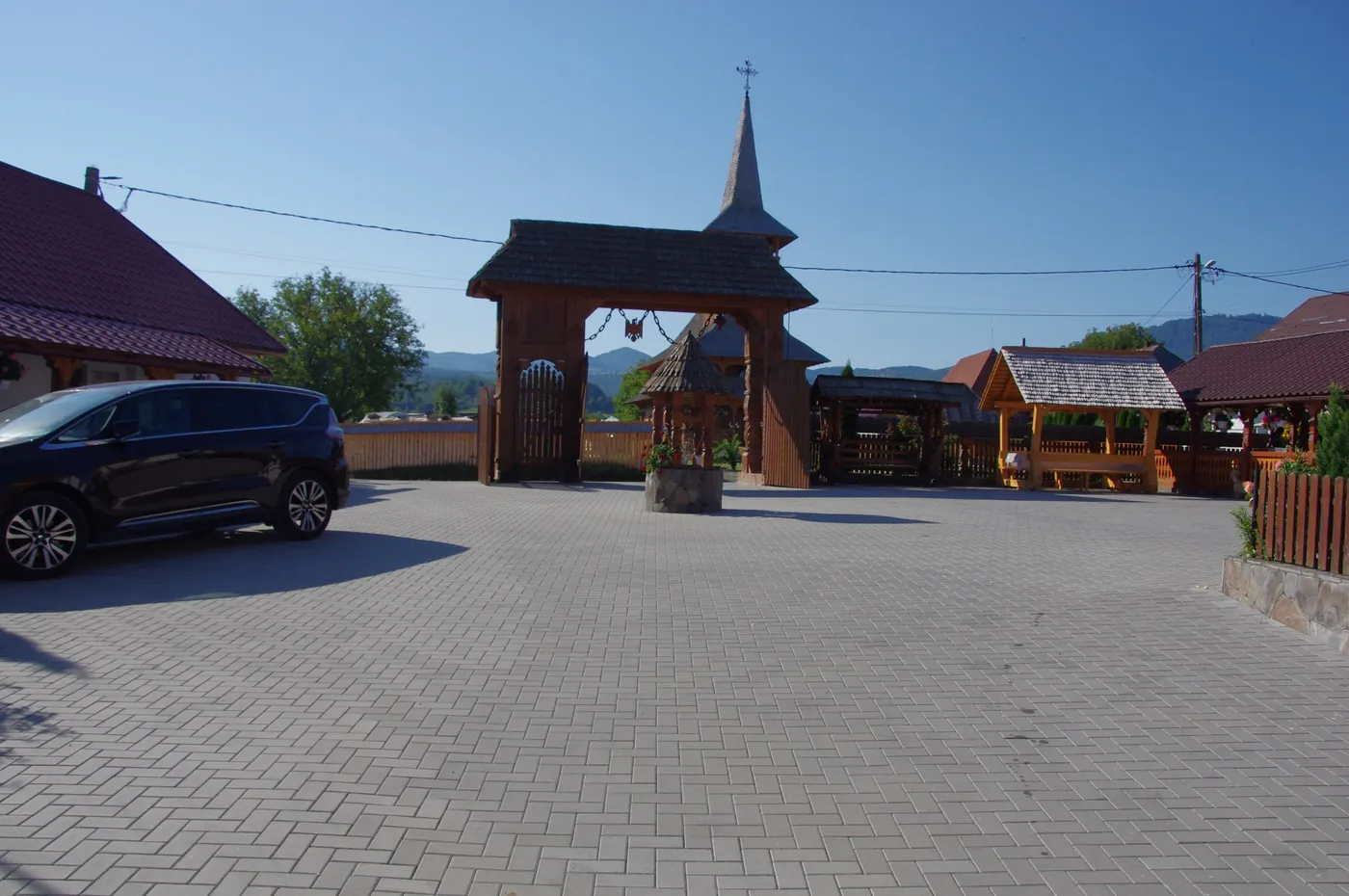 Poarta de lemn sculptat și foișoarele din curte
